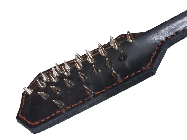 Black leather paddle with chrome spikes on a white background